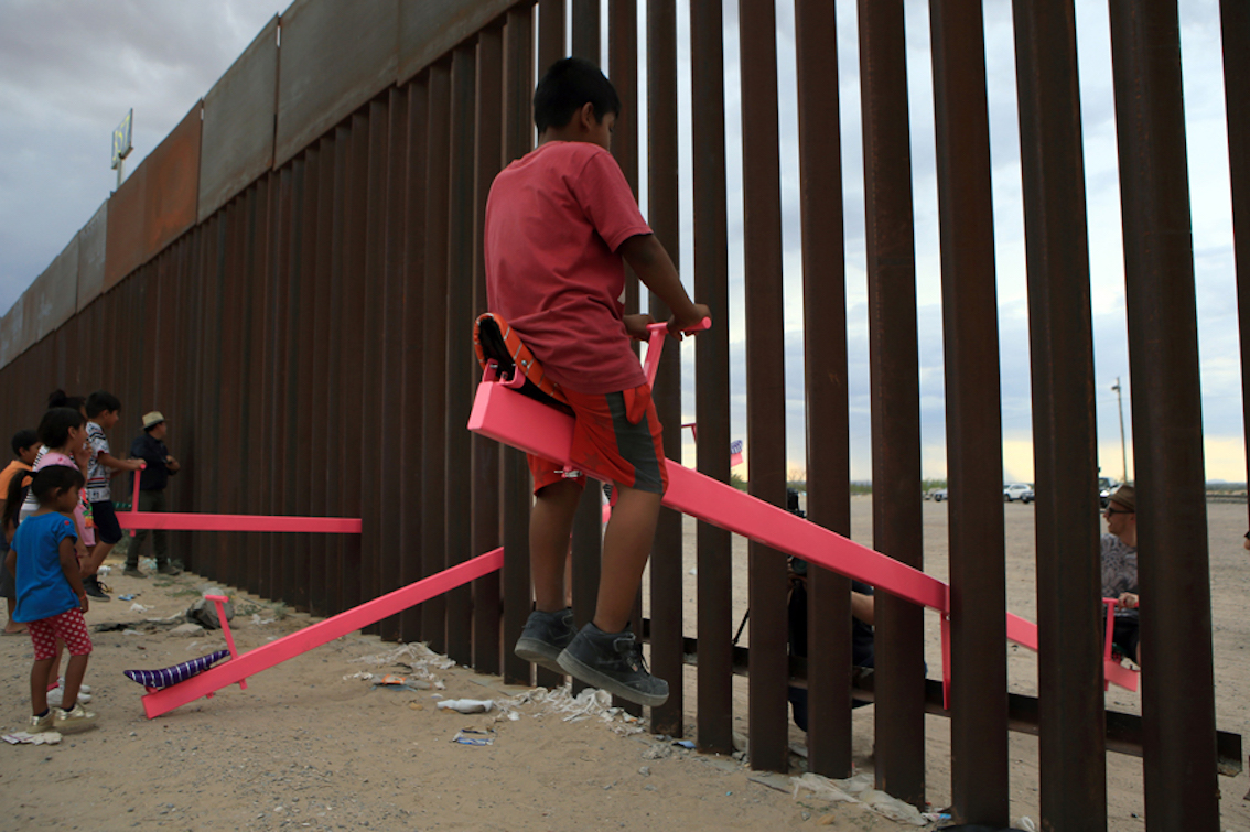 LUIS TORRES 28 luglio, Ciudad Juarez, Messico. Bambini giocano sulle altalene installate dal designer californiano Ronald Rael tra le sbarre del muro che divide Stati Uniti e Messico